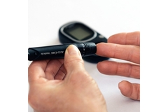 Image A person pricks their finger to check their blood sugar.